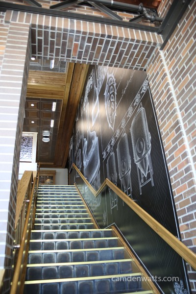 Stairs to the self-guided tour are lined with chalk board wall paper filled with beer art